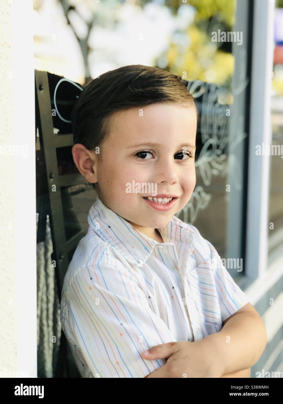 ragazzo di 4 anni contro una vetrina del negozio Foto Stock