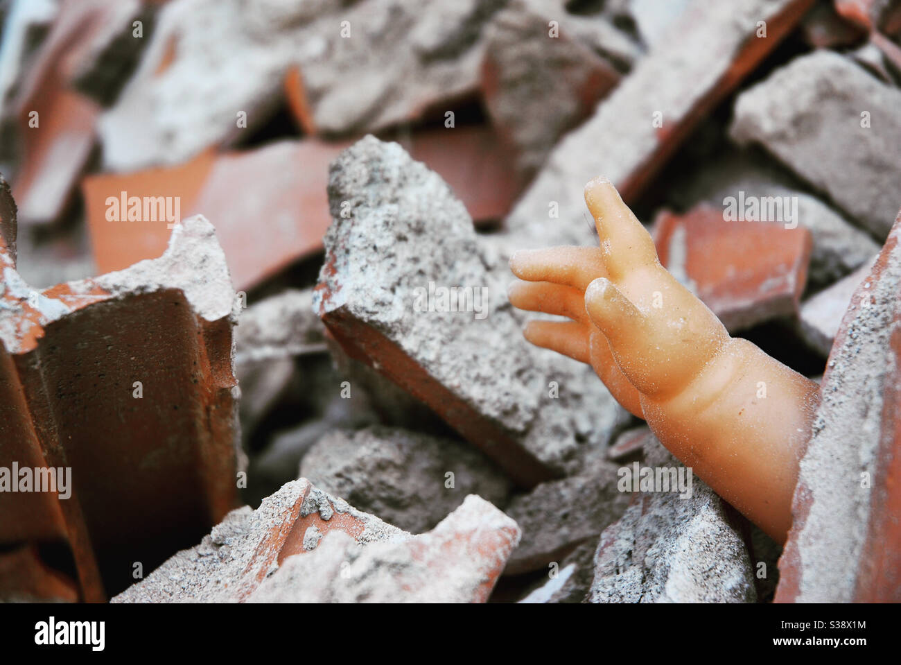 Bambola sotto le macerie - Immagine stock catturata con smartphone