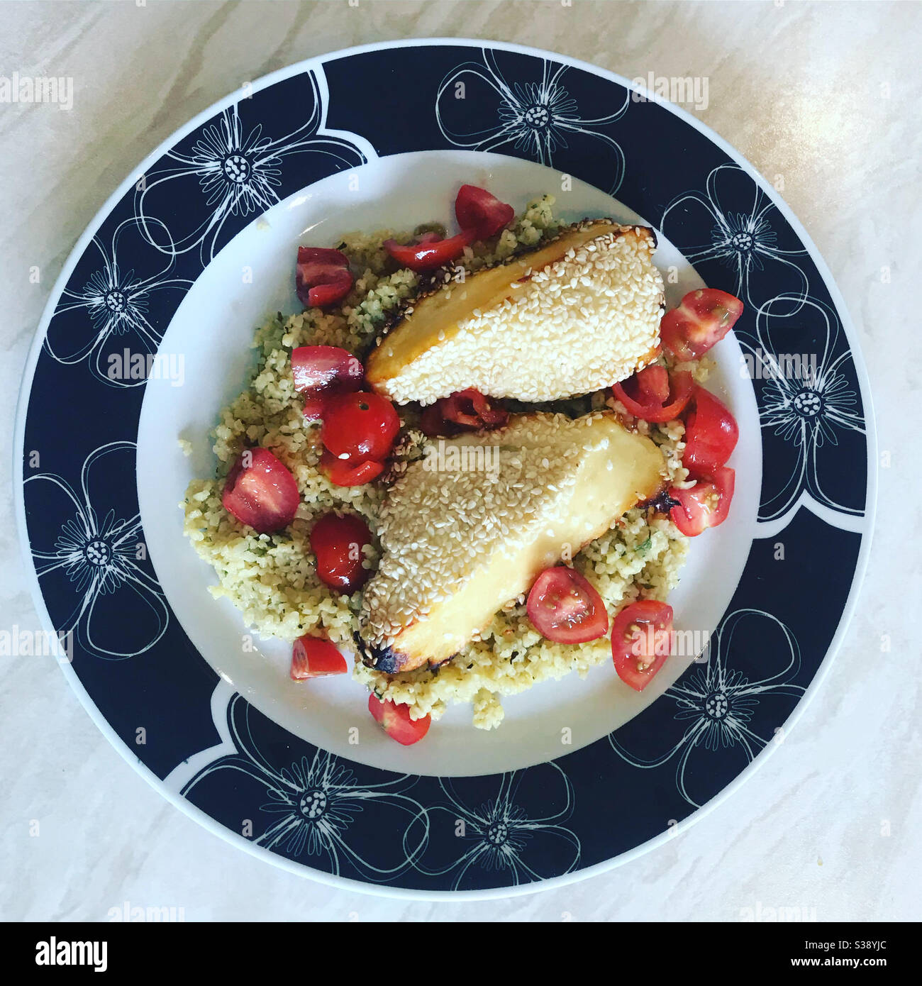 Halloumi in crosta di miele e sesamo con Tabbouleh su un piatto. Agosto 2020. - Immagine stock catturata con smartphone