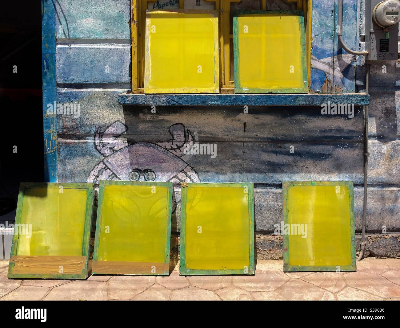 Le cornici per la serigrafia si appoggiano contro una parete rustica in legno a Santa Rosalia, Baja California sur, Messico. Foto Stock