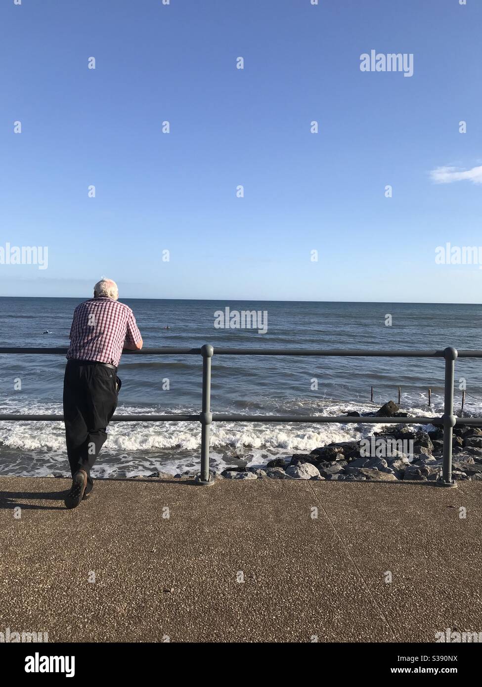 Uomo che guarda il mare a Pendine, Carmarthensshire, Galles. - Immagine stock catturata con smartphone