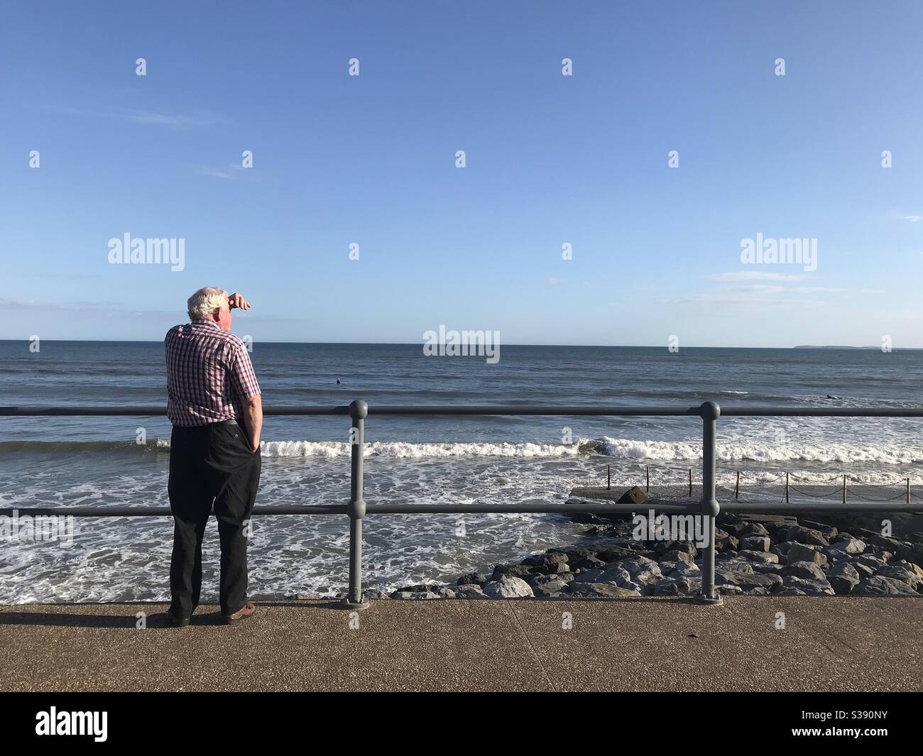 Uomo che guarda il mare a Pendine, Carmarthensshire, Galles. 13 luglio 2020. Foto Stock