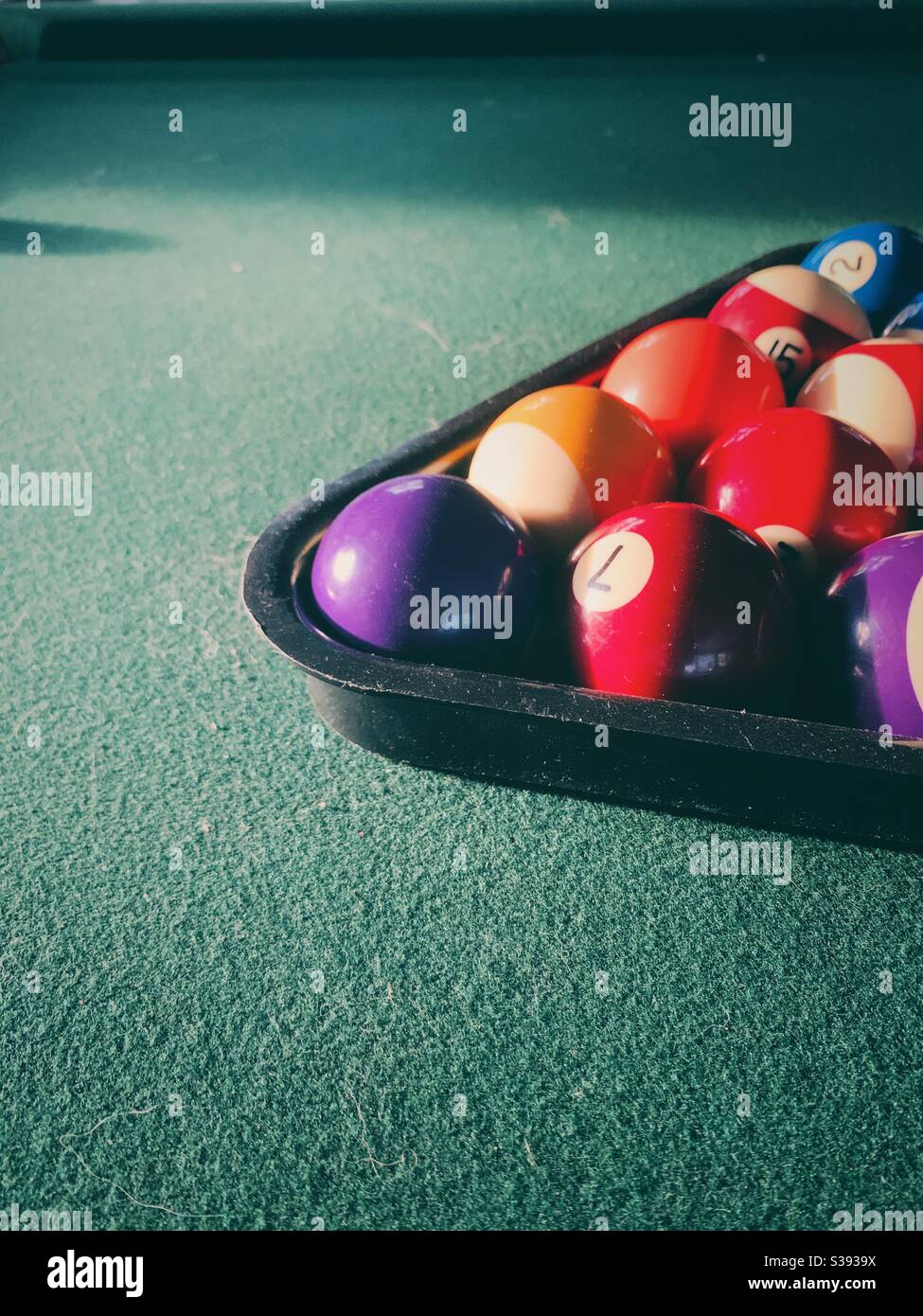 Palline da piscina in rack su un tavolo da biliardo verde. Foto Stock