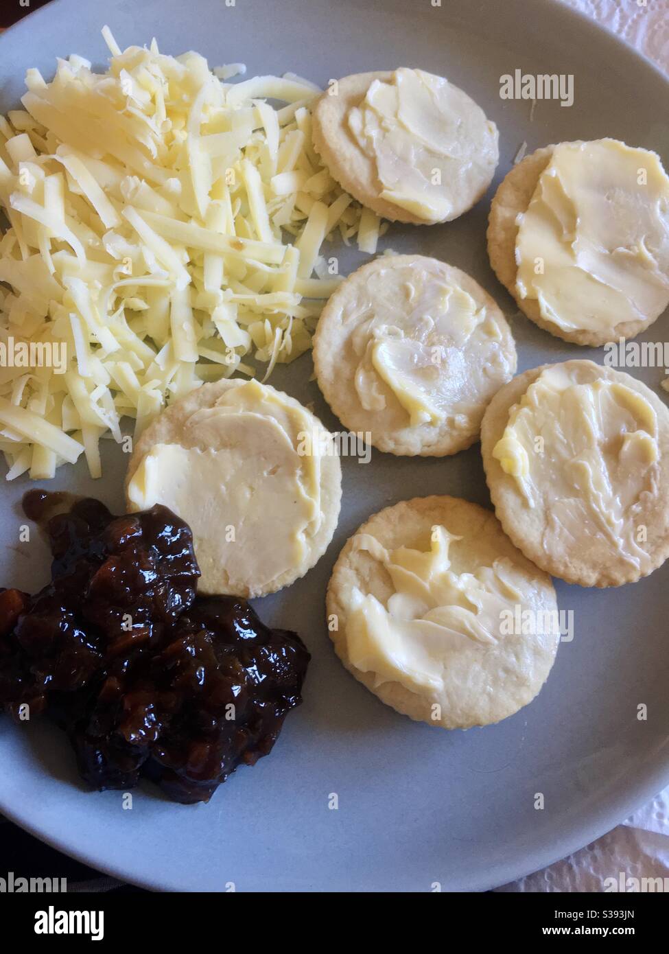 Cracker fatti in casa con rasature di burro, formaggio grattugiato e chutney di sottaceti Foto Stock