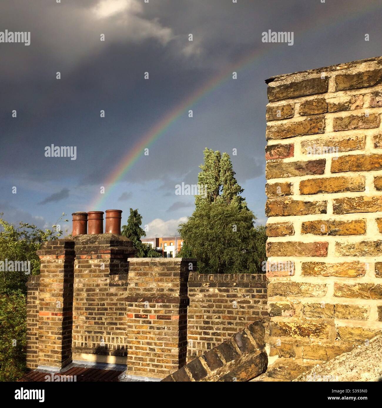 Un arcobaleno sopra i pentole del camino a Londra, Regno Unito Foto Stock