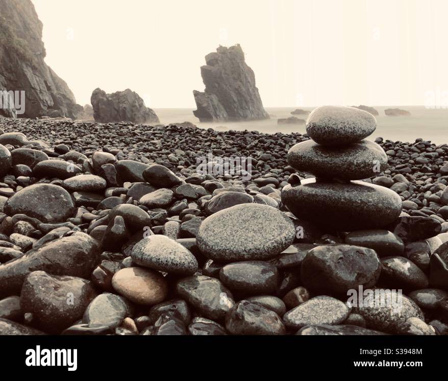 L'immagine è stata scattata in tempo tempestoso su una spiaggia con formazioni rocciose e pietre lungo la costa Foto Stock