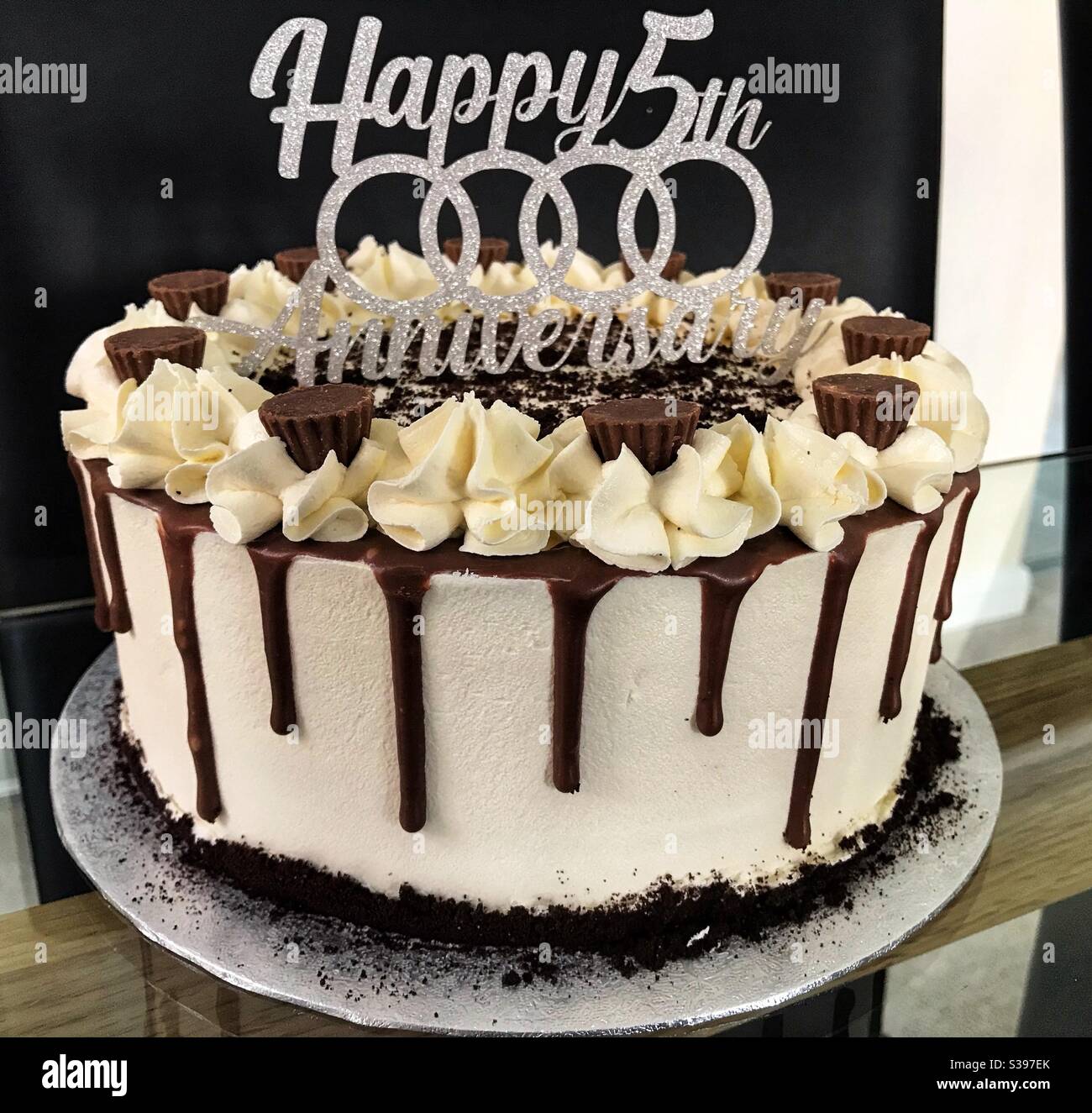 Torta di gocciolamento per il quinto anniversario di matrimonio con un topper di torta Anelli Audi Foto Stock