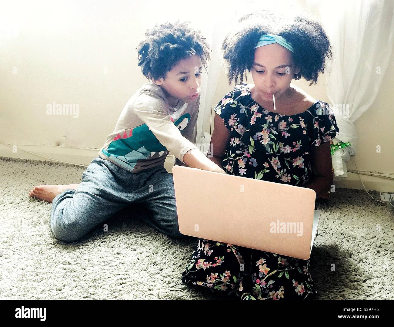 Due bambini da corsa misti sul loro laptop. Foto Stock