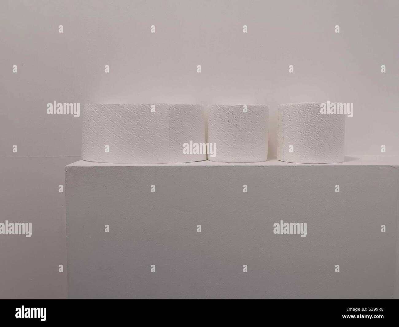 Rotoli di carta igienica su sfondo bianco in bagno Foto Stock