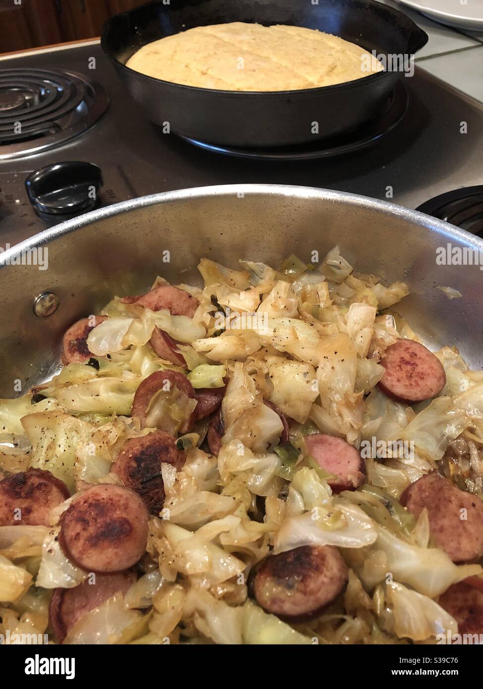 Cipolle di cavolo fritte in stile meridionale e salsiccia con pane di mais caldo - Immagine stock catturata con smartphone