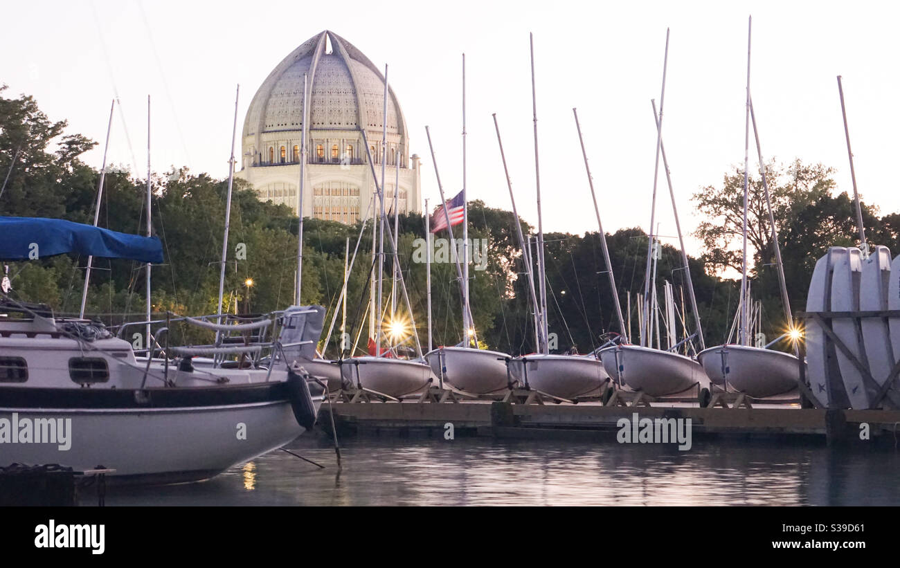 Il Tempio di Baha'i al tramonto dietro le barche nel porto di Wilmette al largo del lago Michigan. Foto Stock