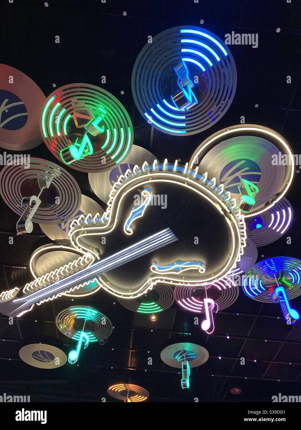 Soffitto al neon a tema musicale con chitarra, dischi e note musicali Foto Stock