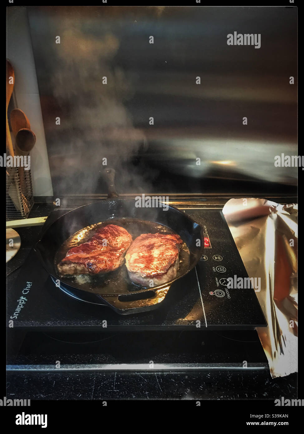 Frittura di bistecche in padella di ghisa. Foto Stock