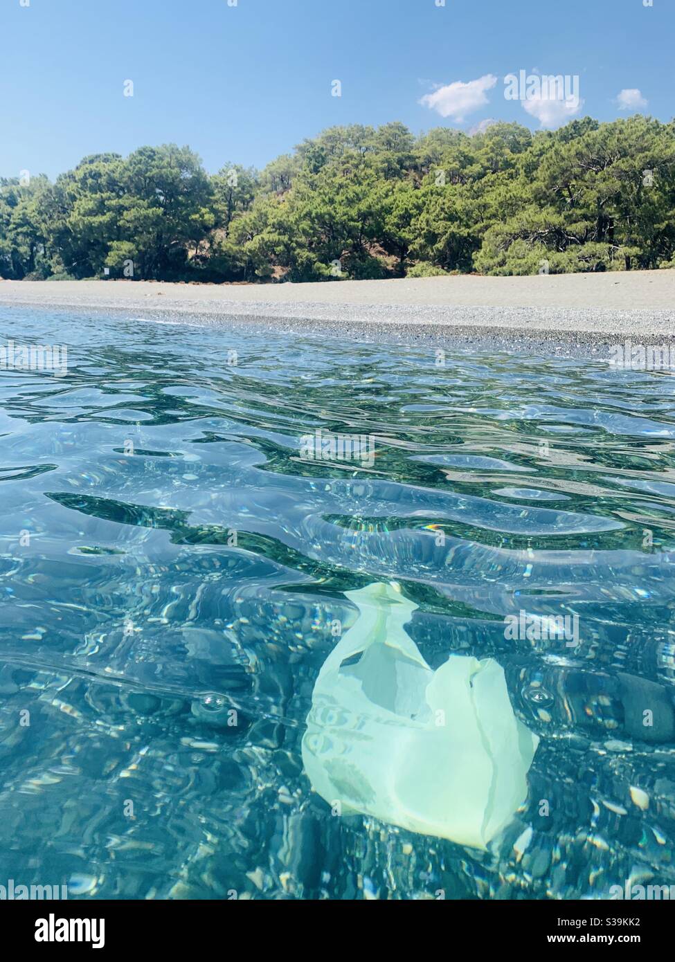 Sacchetto di plastica nell'acqua pulita e pulita della spiaggia di Phaeselis turchia - Immagine stock catturata con smartphone