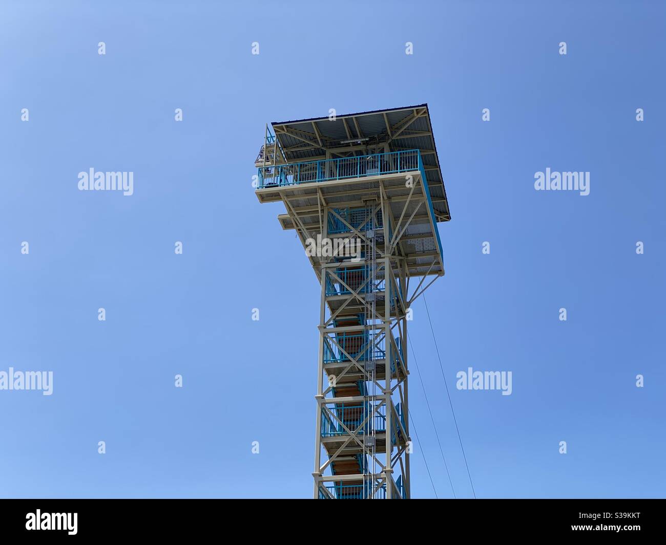 Guardando verso l'alto un'alta torre con zip line Foto Stock