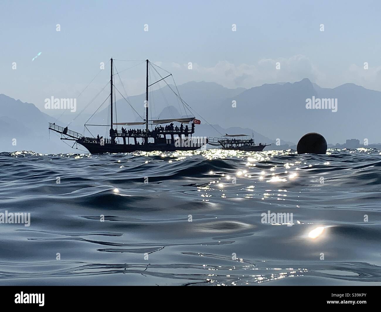 Silhouette di barca pirata a Mermerli spiaggia tramonto Foto Stock