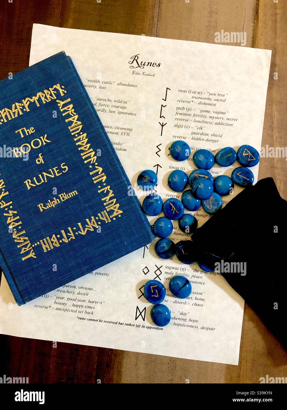 Il Libro delle rune di Ralph Blum con un sacco di pietre rune di agata blu e simboli mitologici. - Immagine stock catturata con smartphone