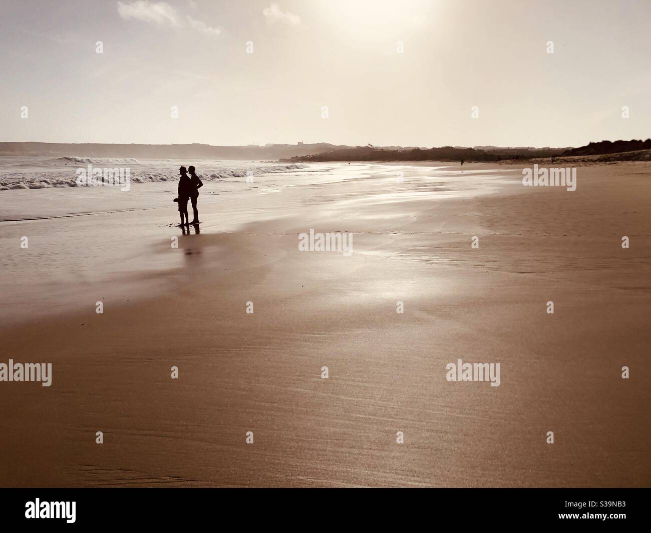 Silhouette di due persone su una spiaggia vuota in inverno Foto Stock