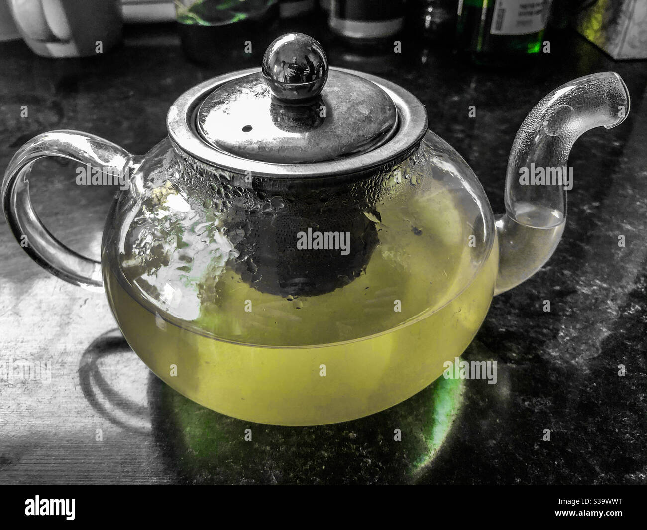 Tè alla menta fatto in casa che si diffonde in una teiera di vetro. - Immagine stock catturata con smartphone