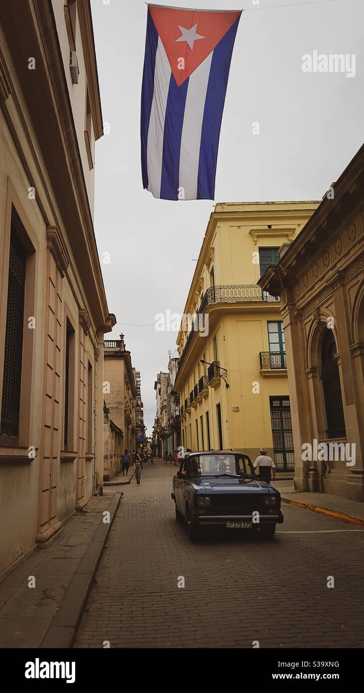 Strade di l'Avana. La bandiera cubana e un'auto d'epoca Foto Stock