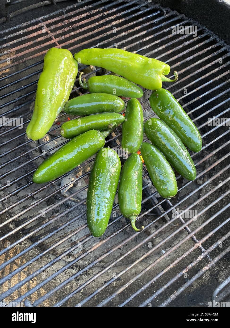 Varietà di peperoni che cucinano su un barbecue all'aperto alla griglia Foto Stock