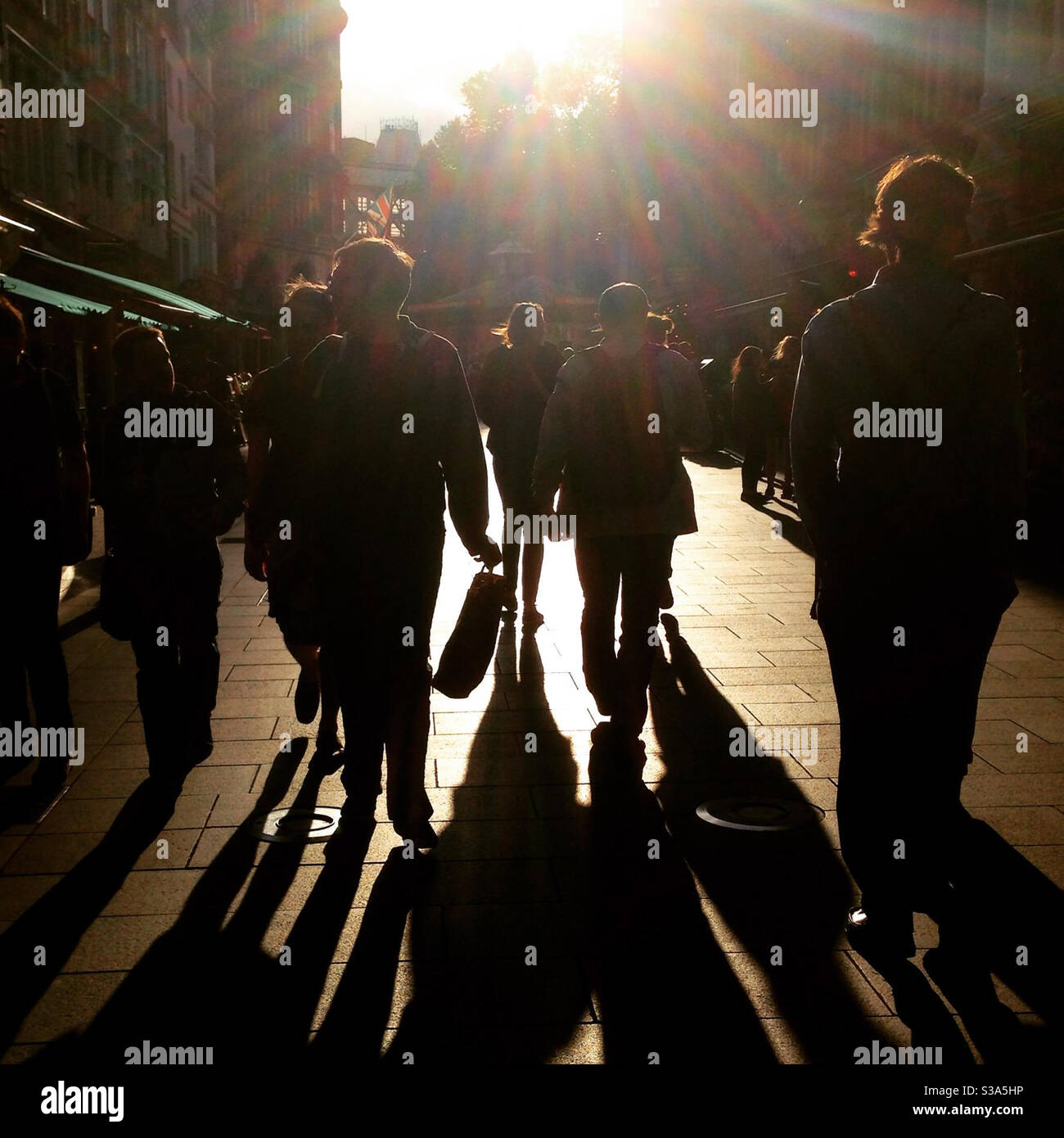 La vita della città di strada è affollata - gente contro il sole a. tramonto Foto Stock