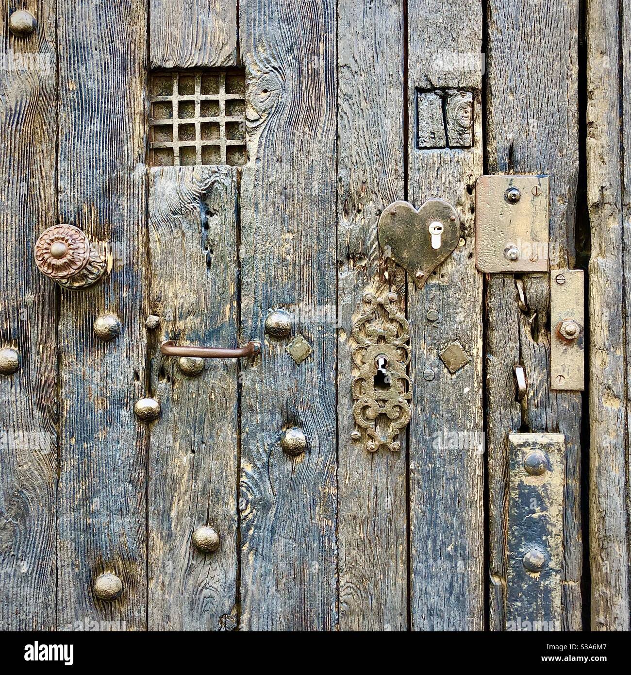 Vecchia porta medievale in quercia con borchie in ferro, maniglie, ferri e riparazioni - Tours, Indre-et-Loire, Francia. Foto Stock