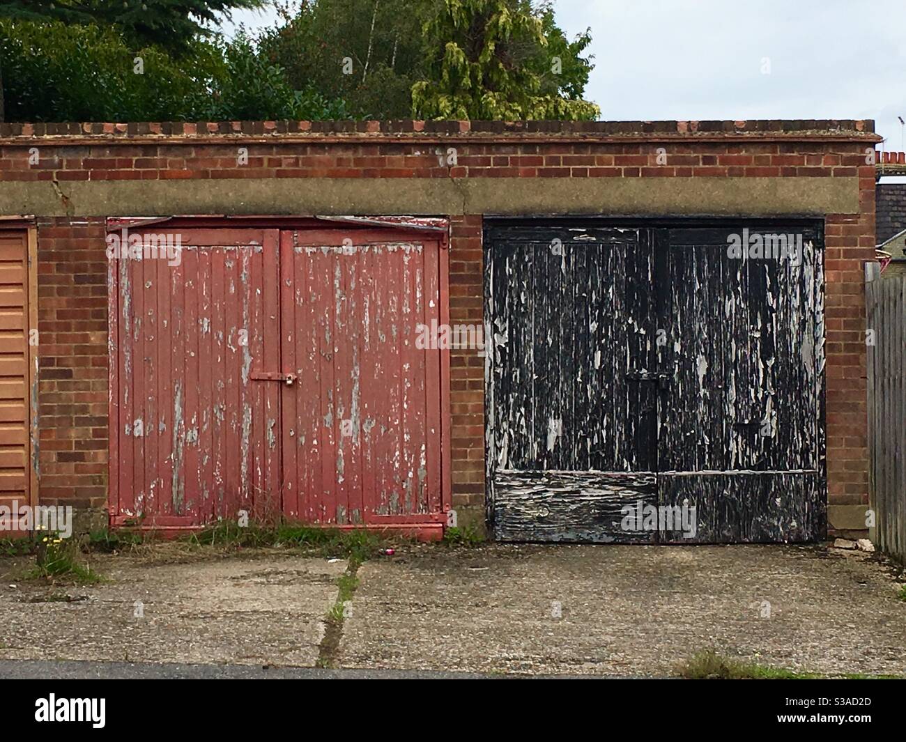 Porte da garage sbiadite che necessitano di verniciatura Foto Stock