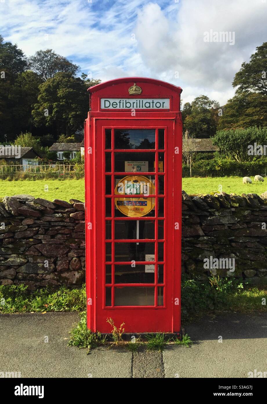Una scatola telefonica britannica rossa in cui è stata convertita Una stazione di defibrillazione per uso pubblico nella campagna britannica Foto Stock