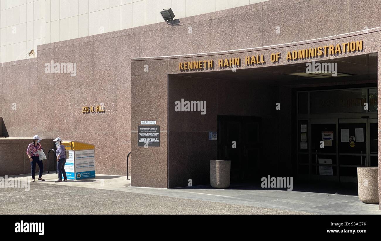 LOS ANGELES, CA, ottobre 2020: Due donne rilasciano i voti presso la cassetta postale sicura fuori dagli uffici della contea nel centro città - Immagine stock catturata con smartphone