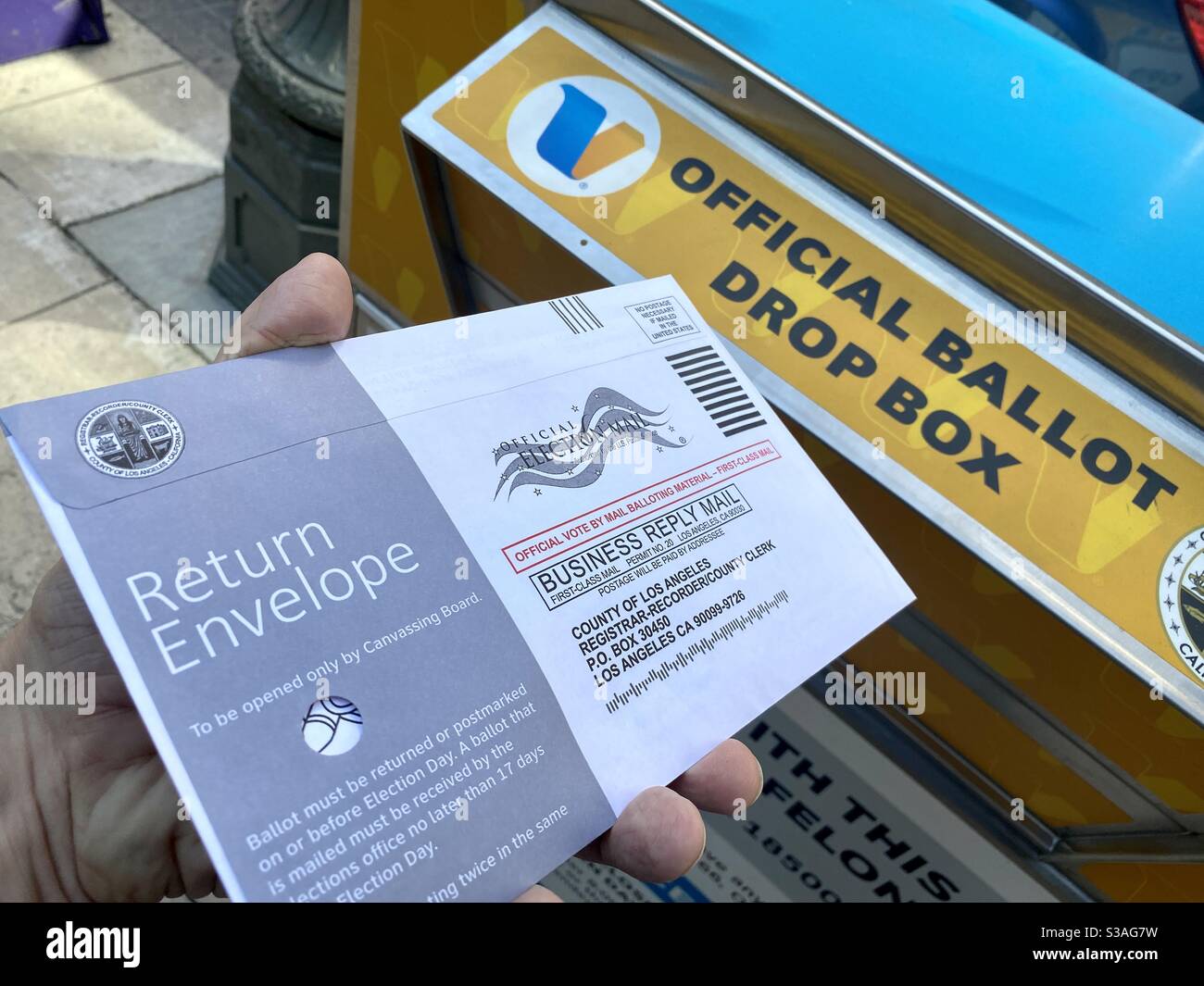 LOS ANGELES, CA, OTT 2020: Il modulo di voto per le elezioni presidenziali degli Stati Uniti del 2020 viene inserito nella busta preaffrancata in una casella di riepilogo delle elezioni ufficiali nel centro città - Immagine stock catturata con smartphone