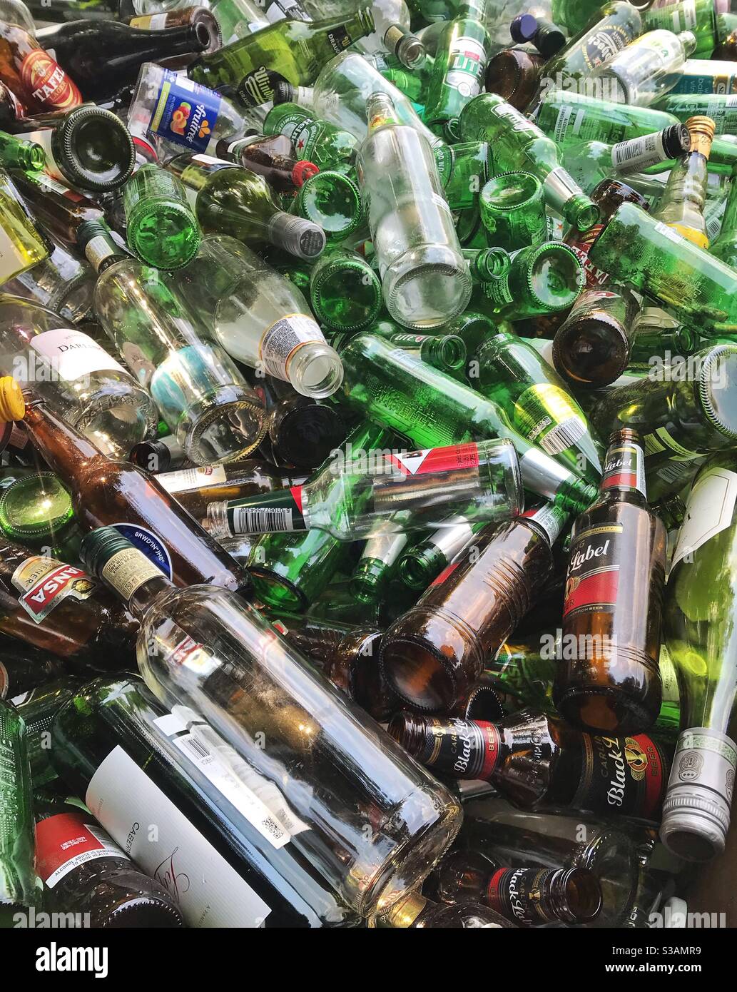 Svuotare le bottiglie di vetro in un salto di riciclaggio. - Immagine stock catturata con smartphone