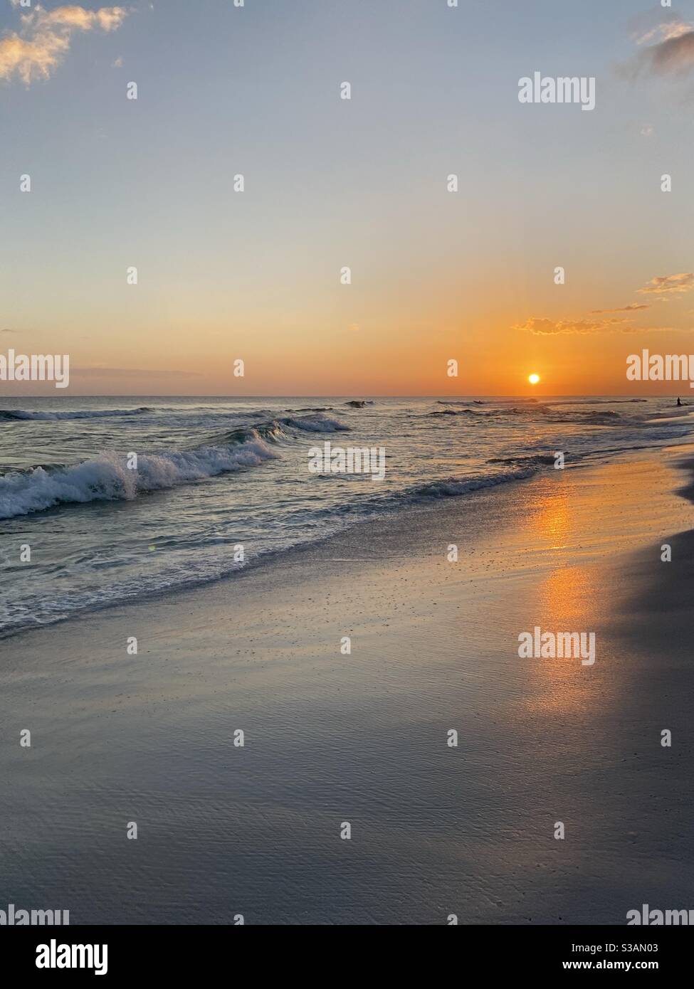 Il sole d'oro tramonta sulle acque color smeraldo del Golfo di Messico Florida con riflessi dorati sulla sabbia Foto Stock