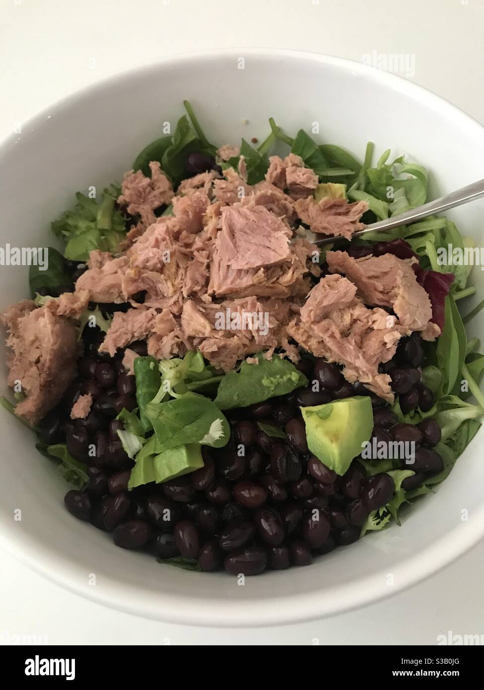 Insalata di tonno, fagioli e avocado servita in una ciotola bianca - Immagine stock catturata con smartphone