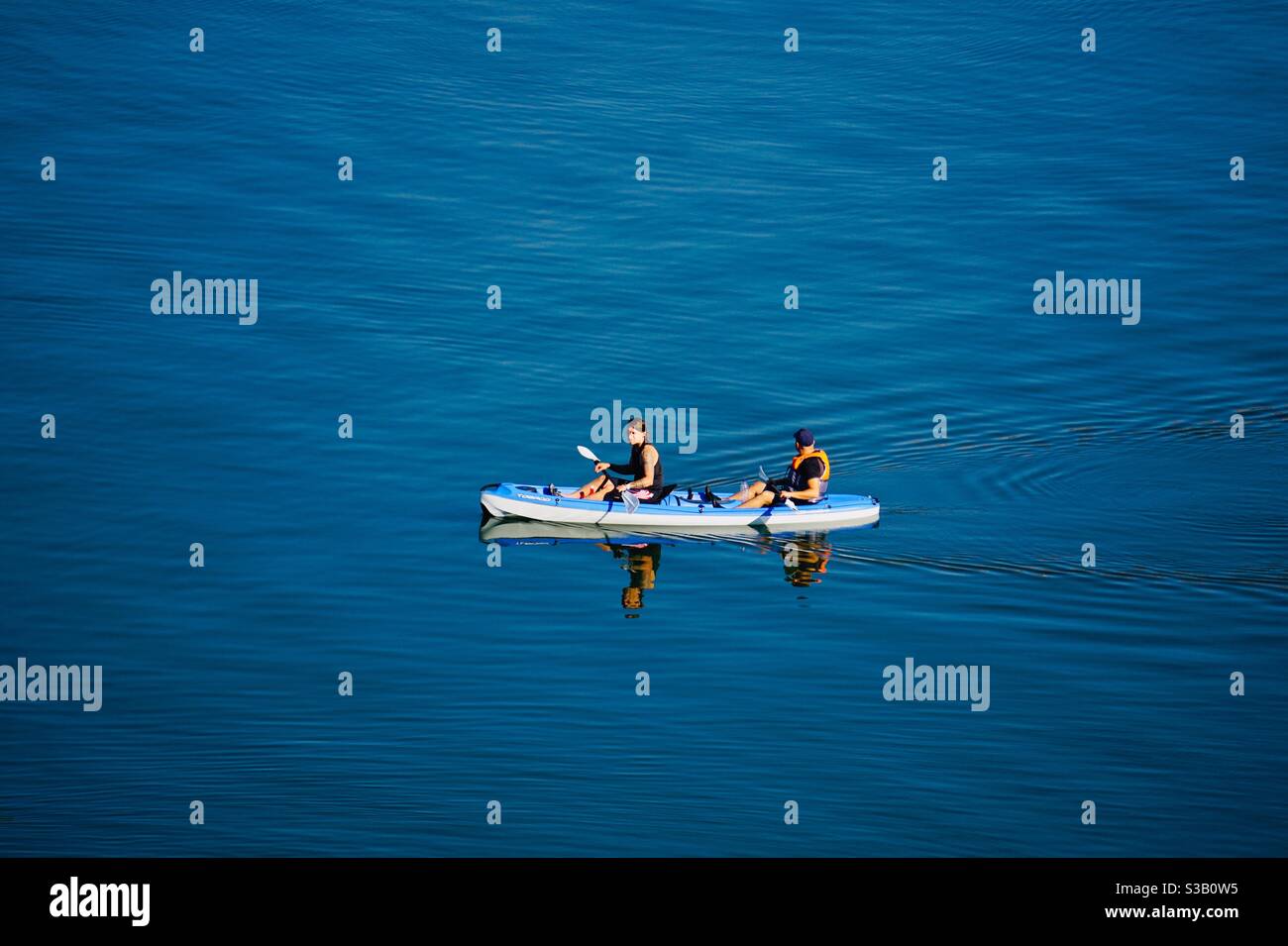 uomini che pagaiano una canoa Foto Stock