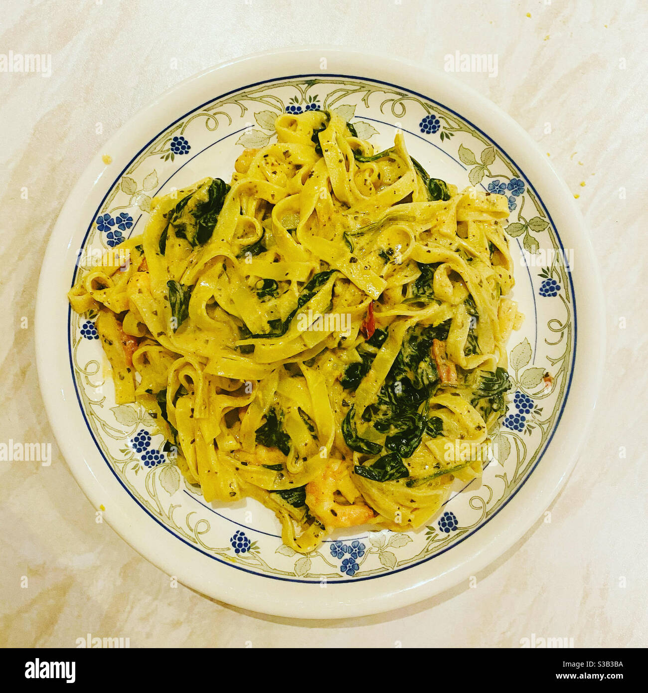 Gamberi del re e tagliatelle fresche con salsa cremosa al limone, spinaci e pomodori. Foto Stock
