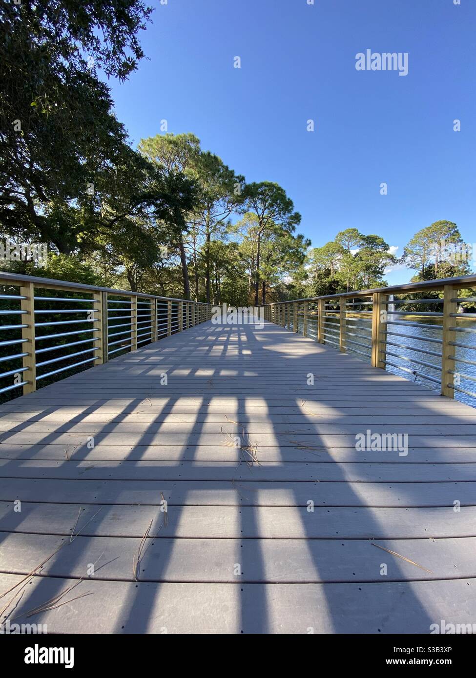 Bassa prospettiva di un lungo ponte sull'acqua del lago Foto Stock