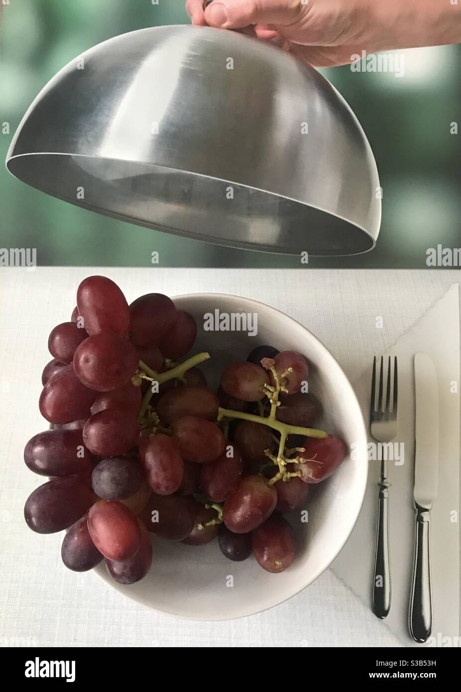 Una ciotola di uva rossa sotto una cupola di cibo - Immagine stock catturata con smartphone