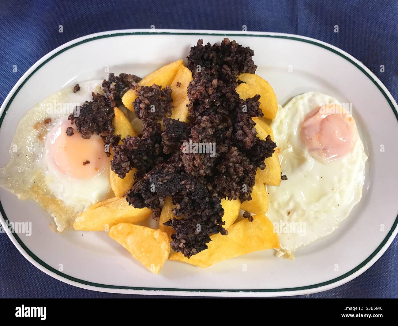 Uova fritte con patatine e budino nero - Immagine stock catturata con smartphone