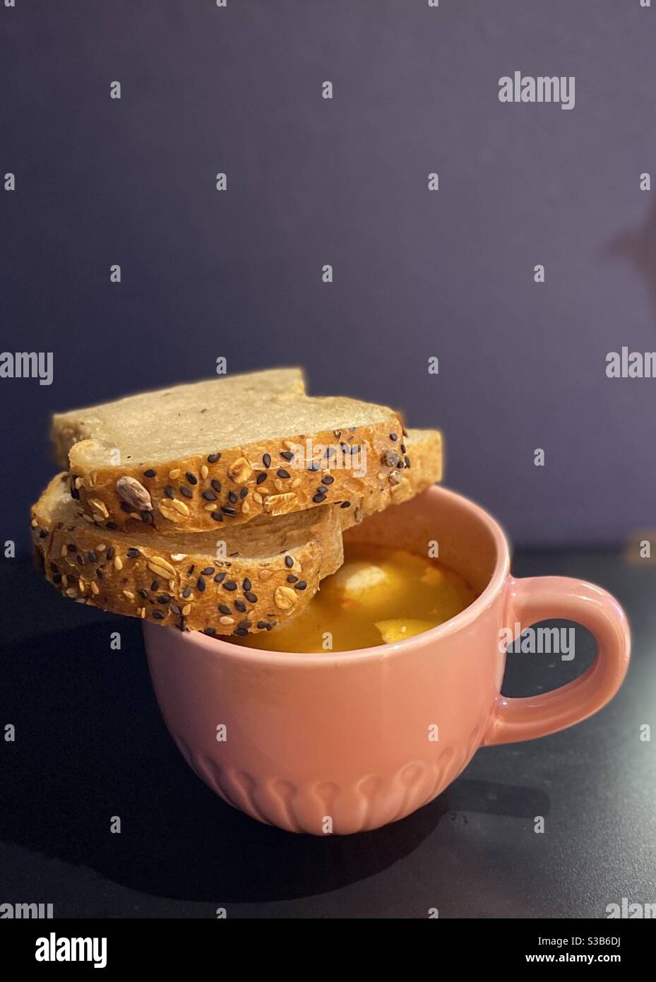 Pane e una tazza di zuppa Foto Stock