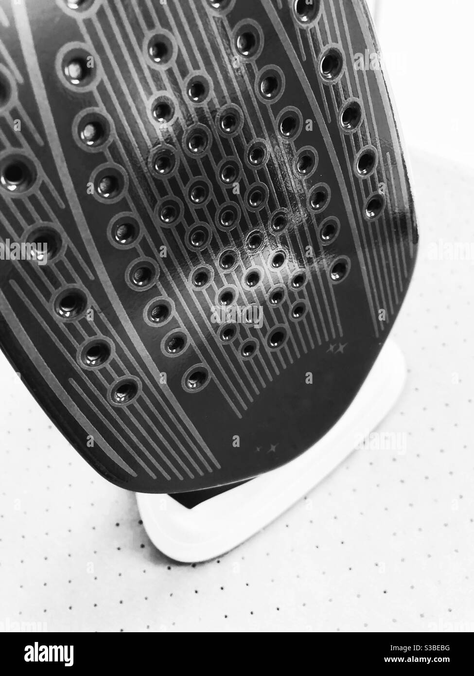 Immagine, bianco e nero ad alto contrasto, che rimane a vita nella parte inferiore del ferro da stiro a vapore dall'alto su uno sfondo molto chiaro. Foto Stock