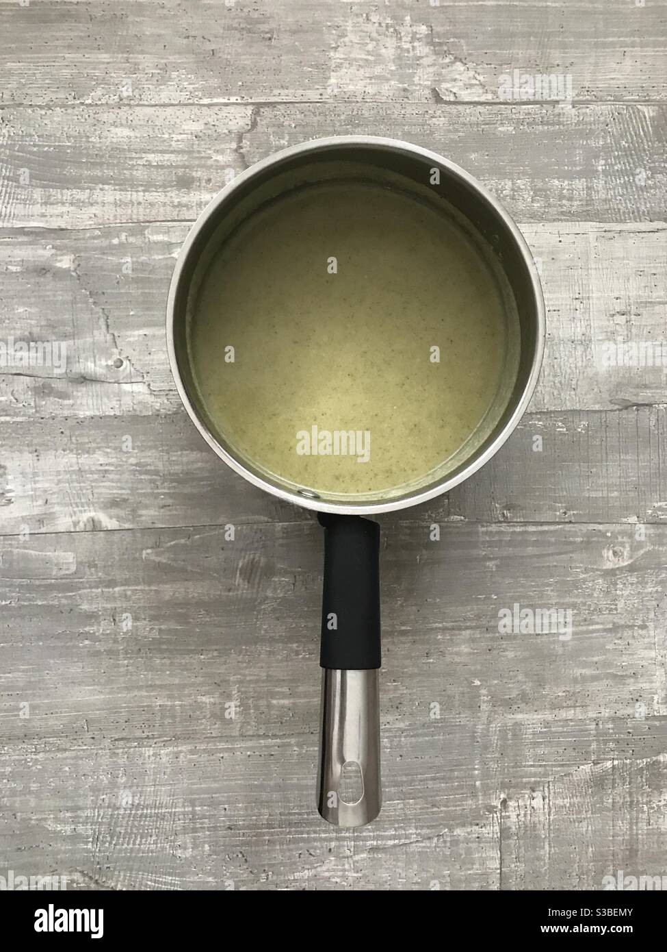 Una padella di zuppa di broccoli fatta in casa su sfondo di legno - Immagine stock catturata con smartphone