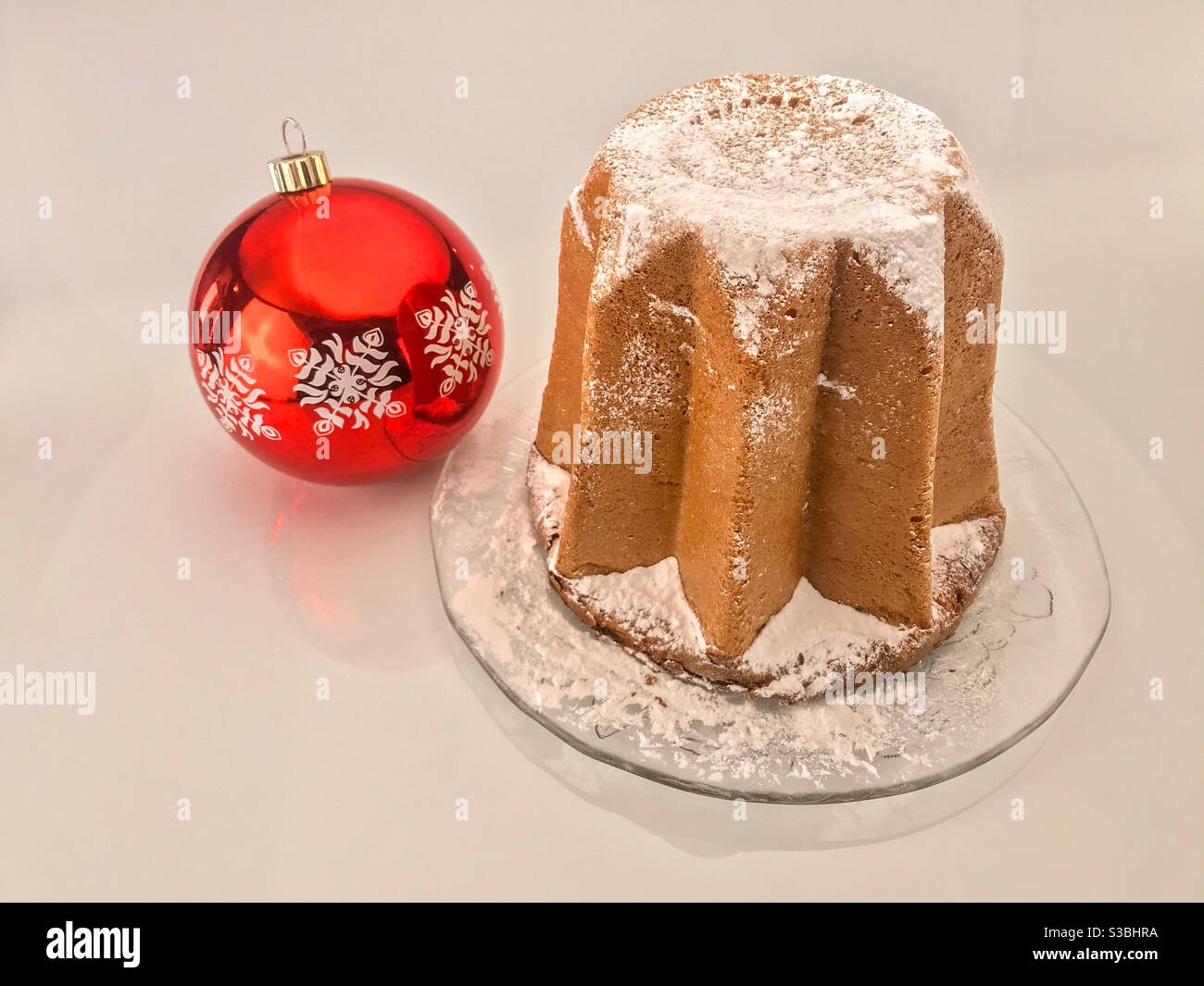 Pandoro, torta di Natale tradizionale italiana, con zucchero a velo vicino alla palla di Natale, - Immagine stock catturata con smartphone