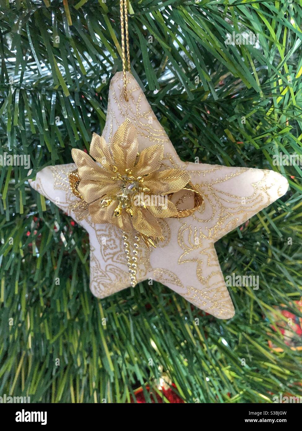 Un ornamento di stella di stoffa fatto a mano appeso in un albero di Natale  Foto stock - Alamy