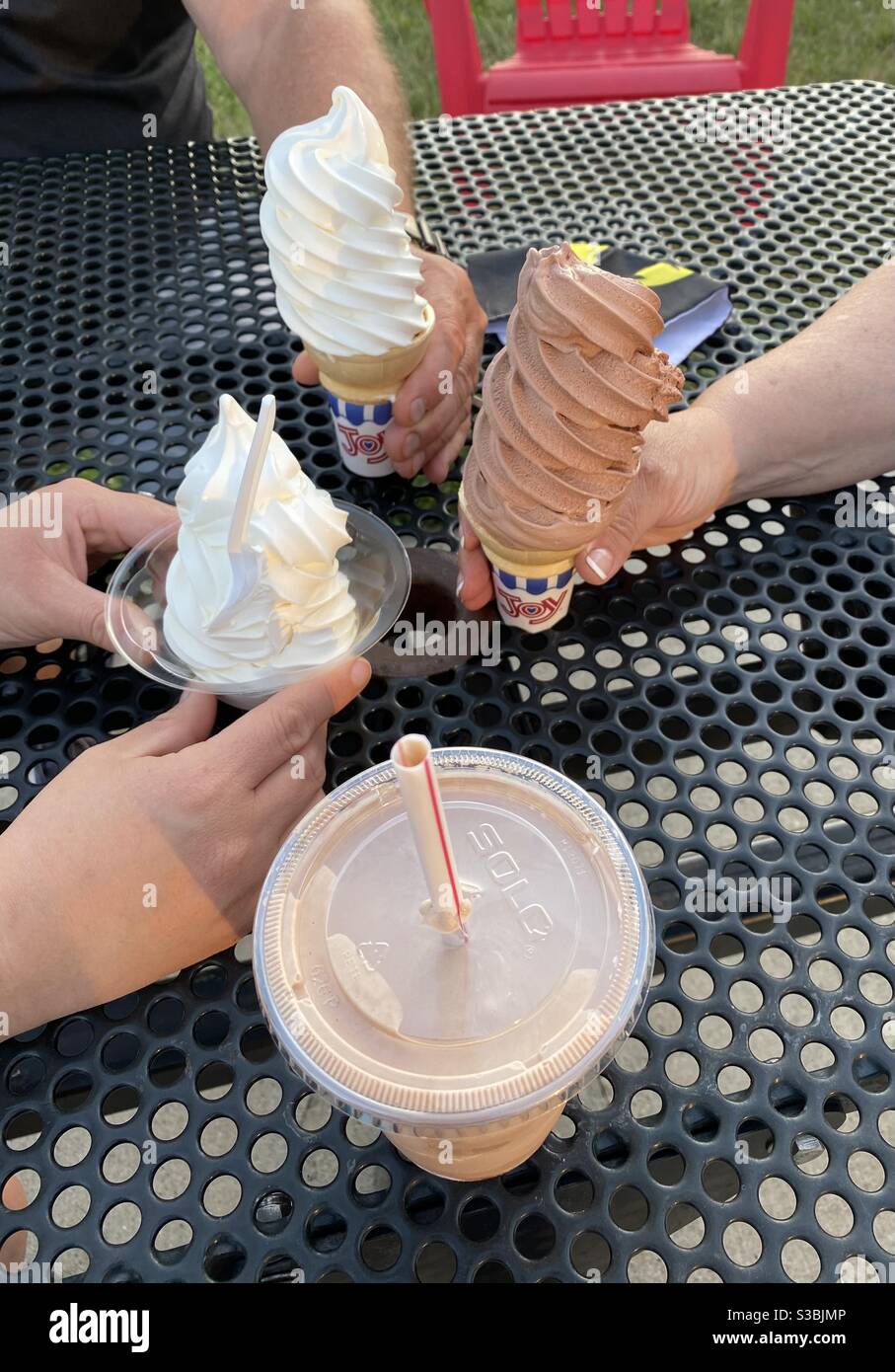 Persone che mangiano coni gelato ad un tavolo da picnic in Wisconsin. Foto Stock
