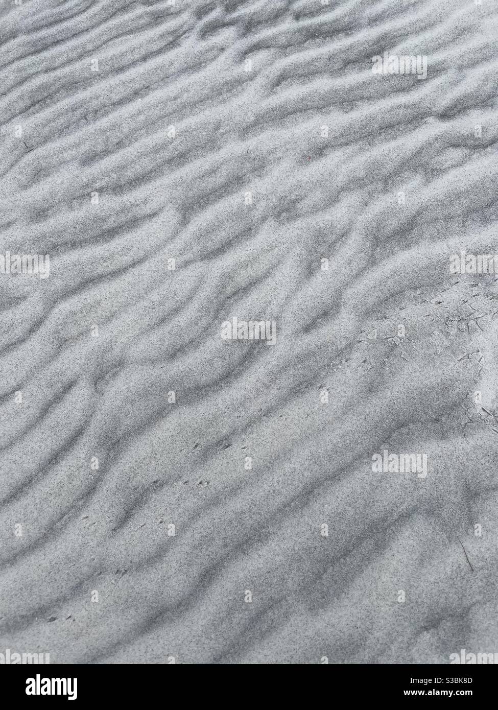 Sfondo astratto di texture e motivi su sabbia bianca Foto Stock
