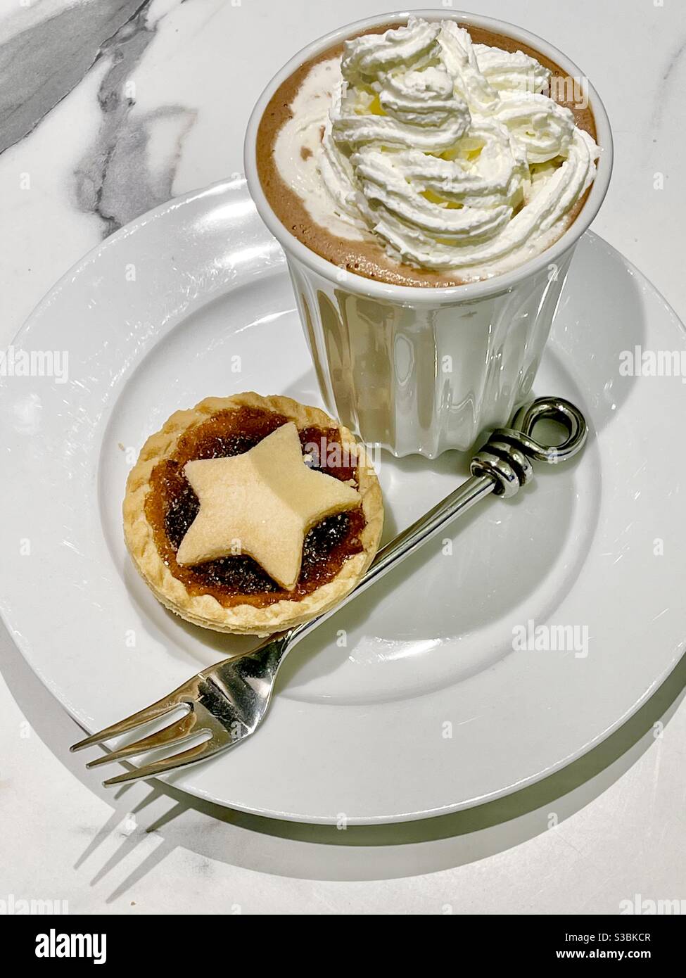 Cioccolata calda con panna e torta di mele su piatto bianco con forcella - Immagine stock catturata con smartphone
