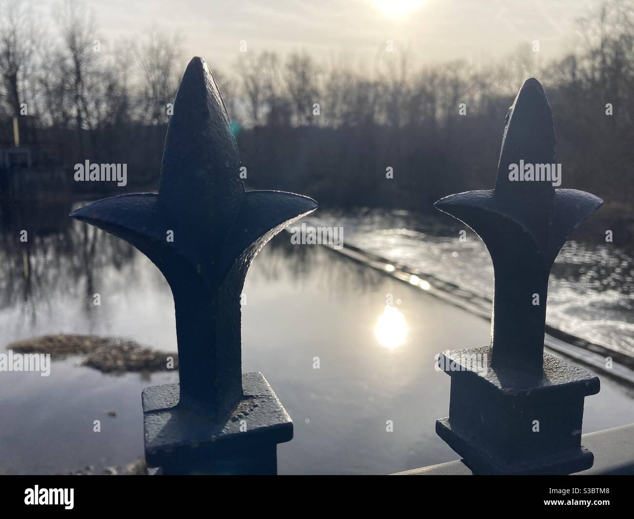 Recinzione a forma di croce mentre il sole sbiadito sullo sfondo inizia a tramontare a Smithville Park. - Immagine stock catturata con smartphone