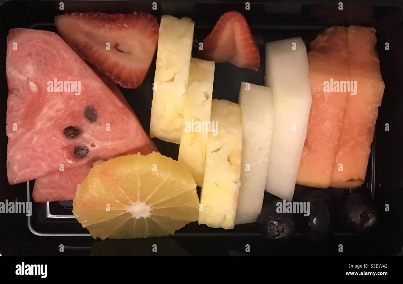 Un piatto di frutta fresca di stagione in un vassoio nero - Immagine stock catturata con smartphone