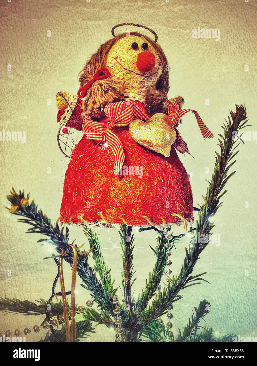 Un angelo interessante e forse divertente che si siede in cima ad un albero di Natale. Non tutto è perfetto, ma hey - è tempo di Natale! Credito fotografico -©️ COLIN HOSKINS. Foto Stock